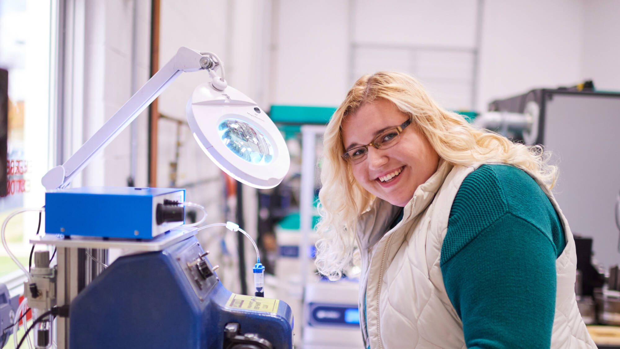 Student smiles while working in a lab